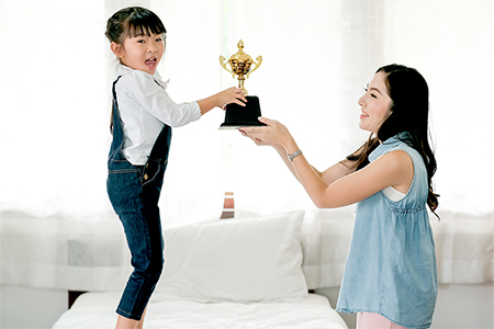 Asian daughter express exciting after get reward as trophy from her mother